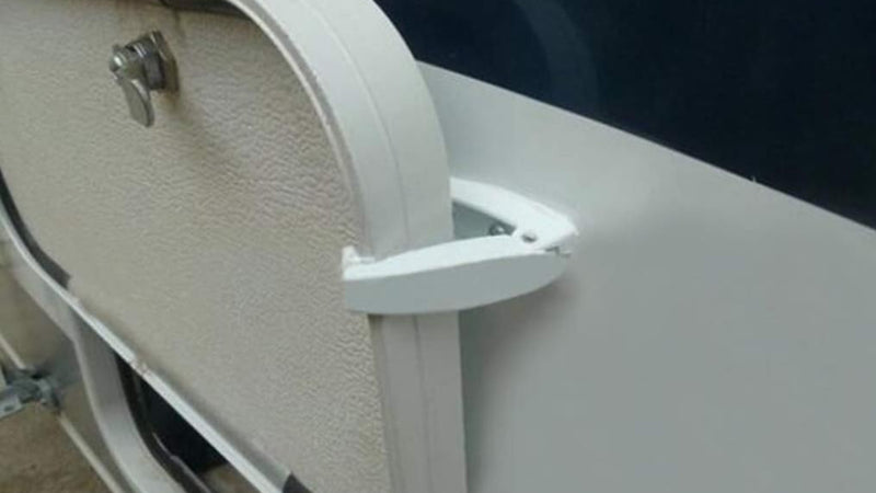 Supplier photograph of a white catch holding an RV storage door open.