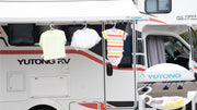 RV awning application photograph showing light clothing suspended from hooks.